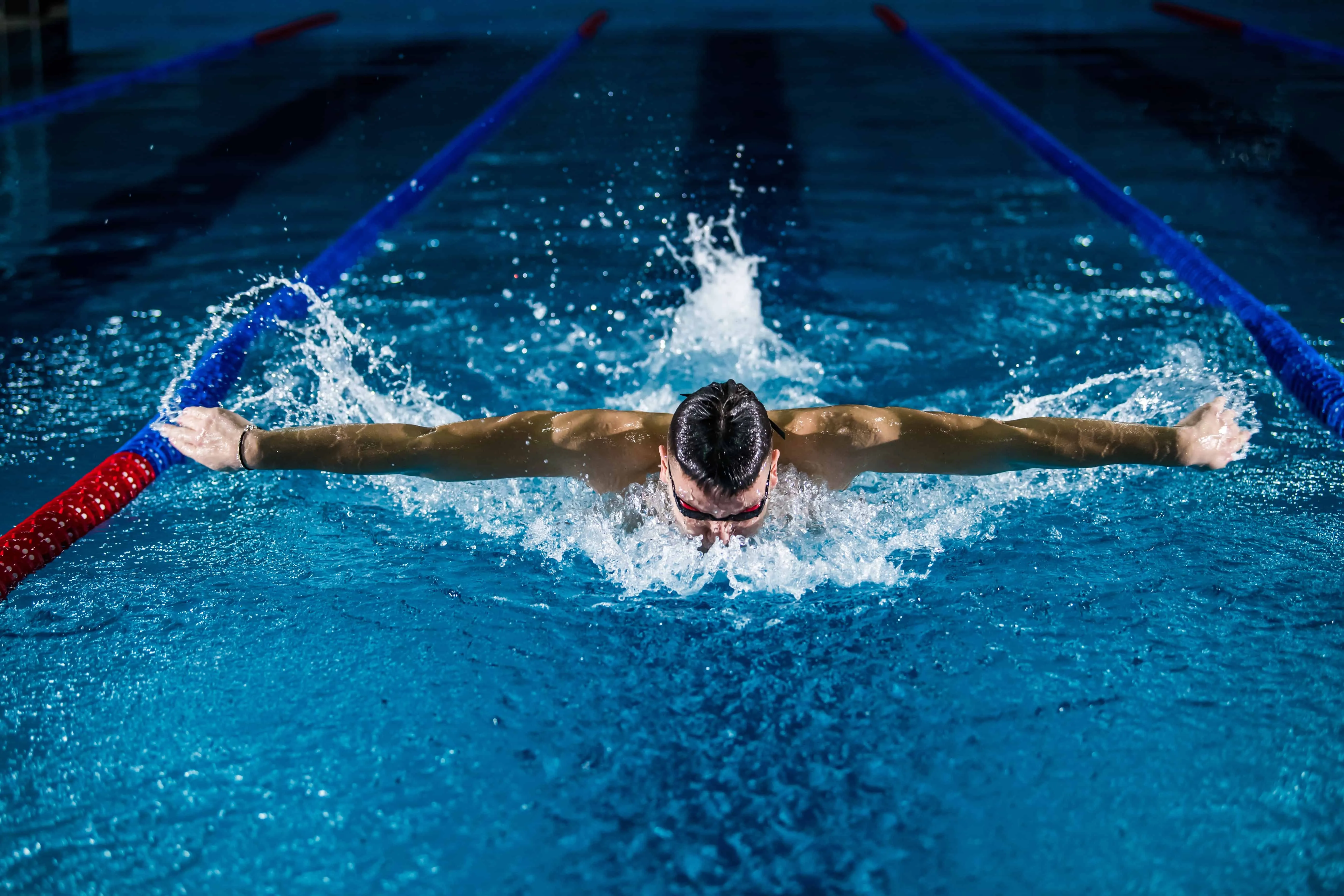 Man swimming butterfly stroke in a pool
